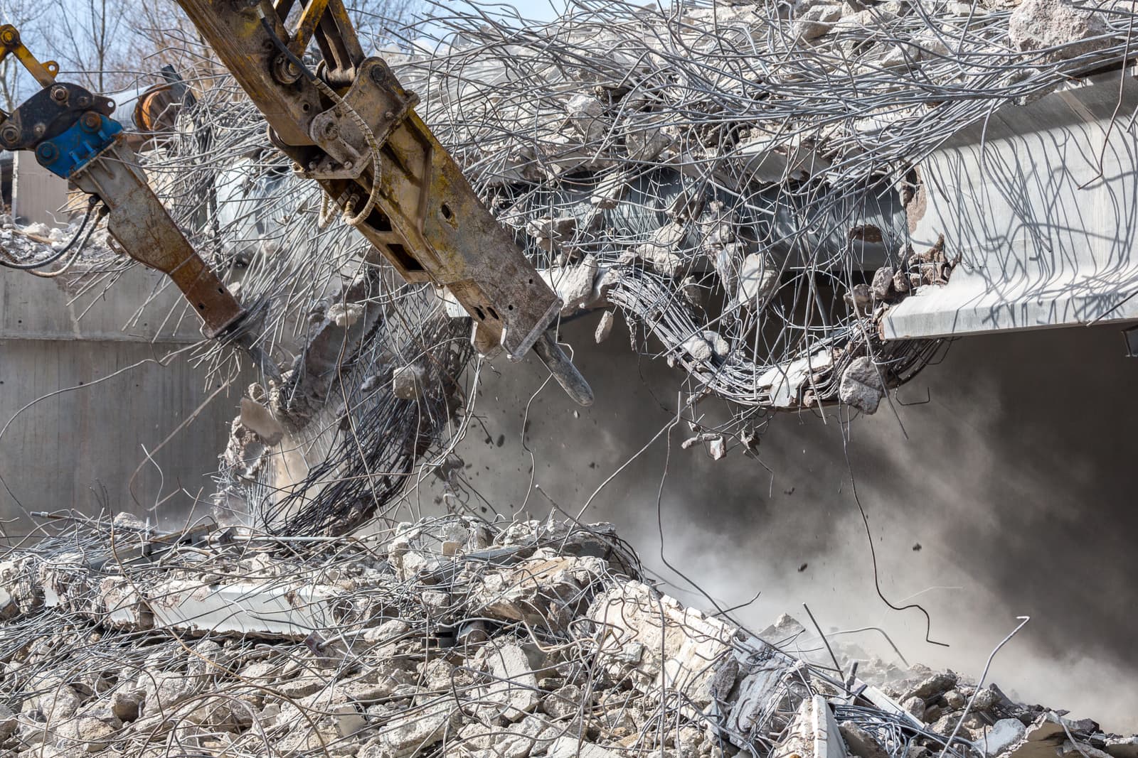 Hydraulic breaker demolishing a reinforced concrete structure
