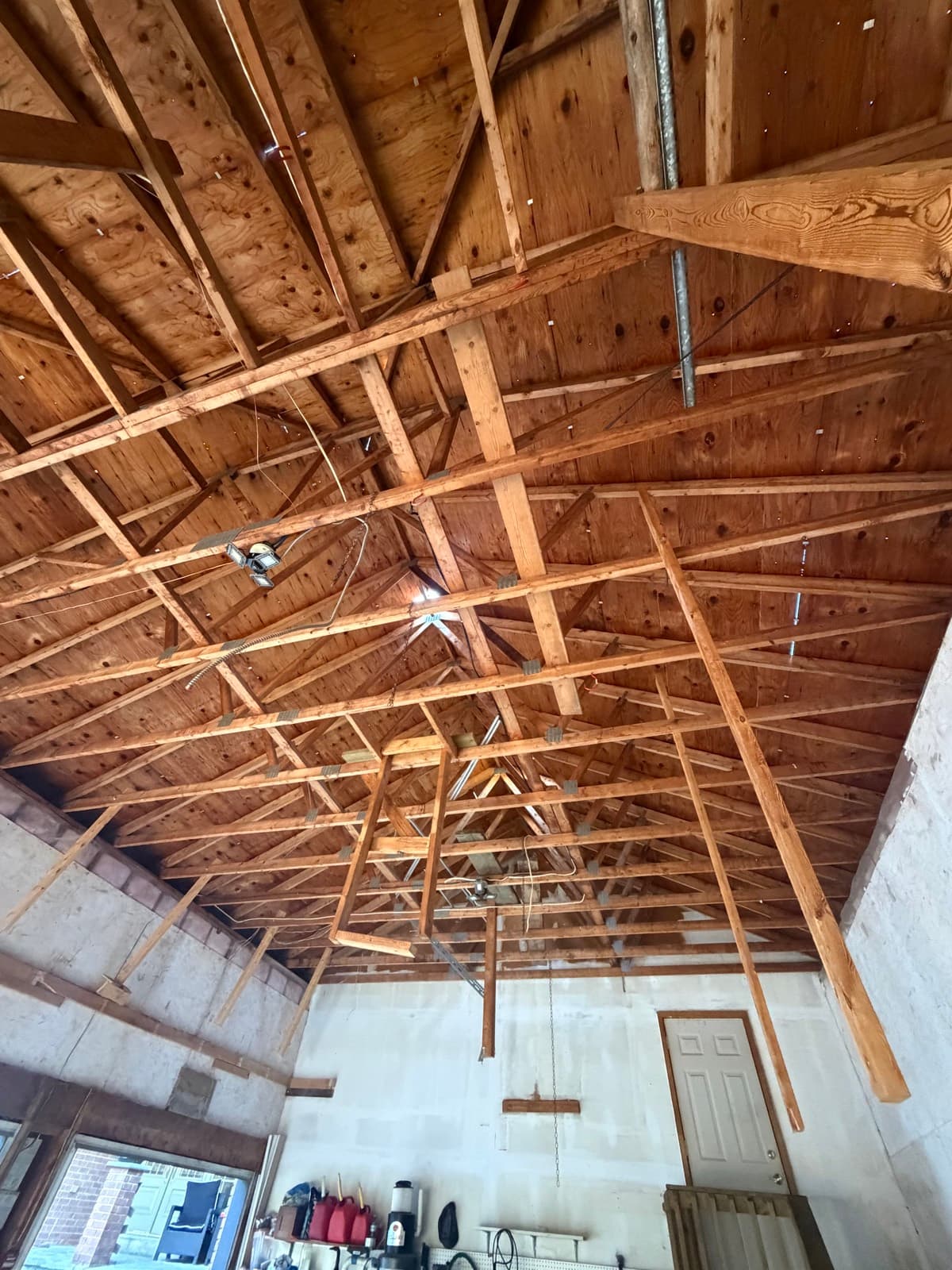 Exposed roof trusses and framing inside an older garage