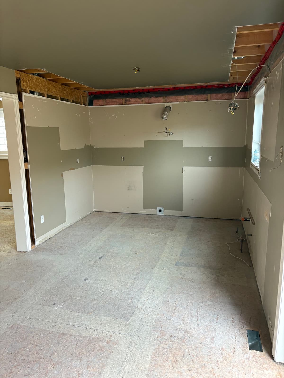 Kitchen with cabinets removed and walls cut back to the subfloor